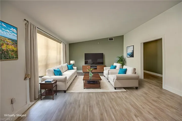 Living area featuring lofted ceiling and wood finished floors