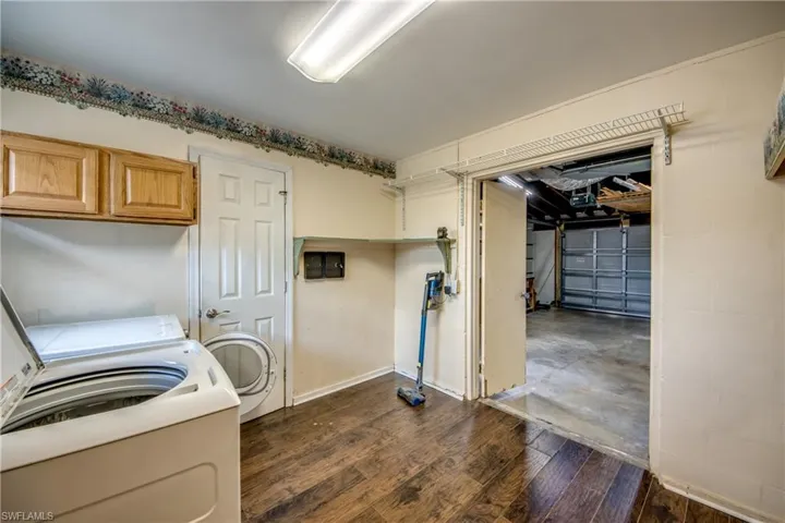 Laundry room with cabinet space and dark wood-type flooring