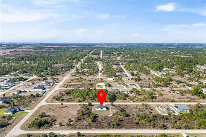 Aerial view of property and surrounding area with nearby suburban area