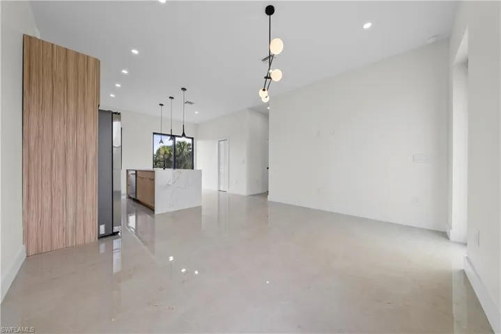 Unfurnished living room featuring recessed lighting and baseboards