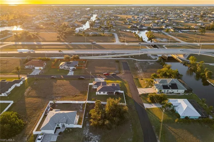 Aerial view at dusk featuring a water view
