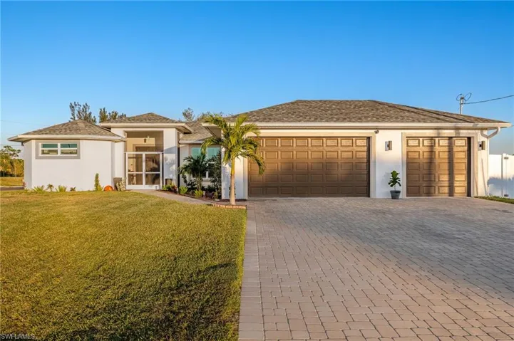 View of front of home with a front lawn and a garage
