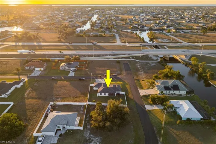 Aerial view at dusk featuring a water view