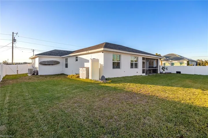 Back of property featuring a sunroom and a lawn