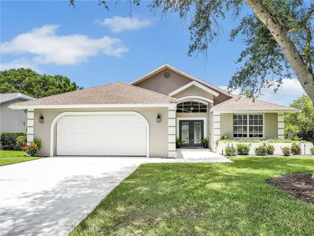 Ranch-style home with a garage and a front lawn