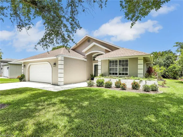 View of front of property with a garage and a front lawn
