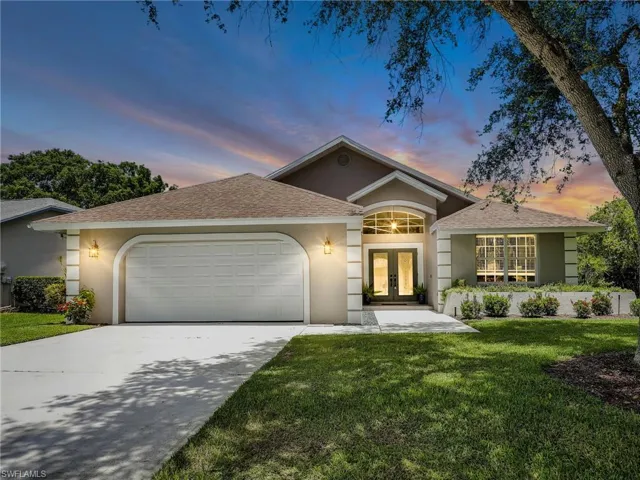 View of front of house featuring a garage and a lawn