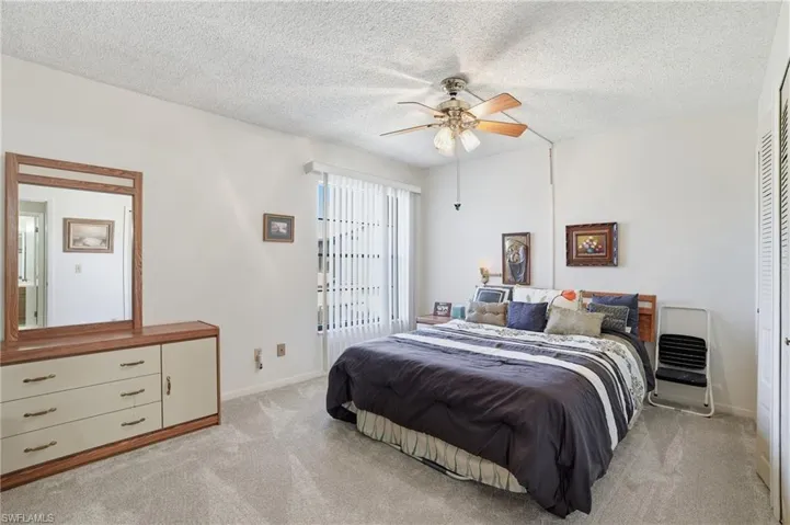 Guest Bedroom with a ceiling fan, light carpet,ccloset