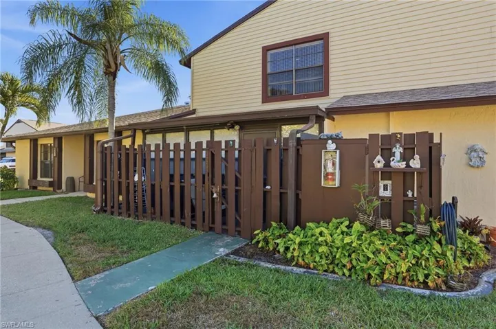 View of side of property featuring a gate and roof with shingles