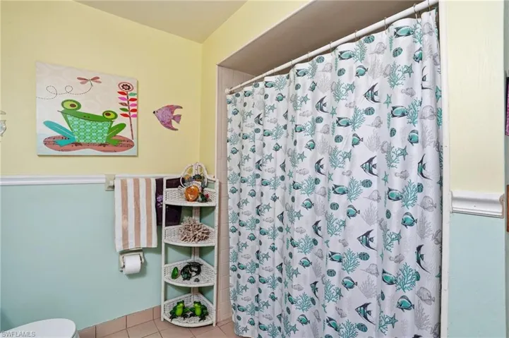 Primary Bathroom featuring vanity, shower/tub and light tile