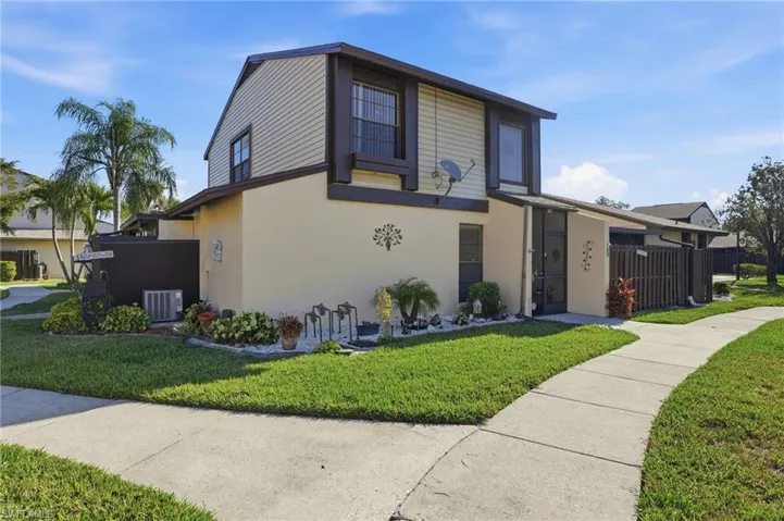 View of front of house featuring stucco siding, a front yard, and lawncare items