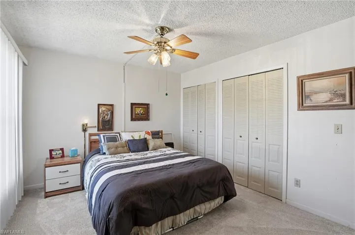 Guest Bedroom featuring carpet, multiple closets, a ceiling fan