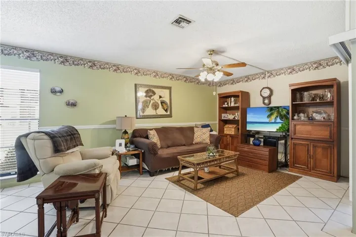 Living area with a ceiling fan, light tile