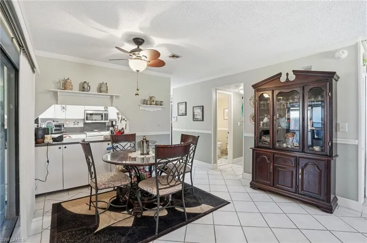 Dining space with ceiling fan, light tile