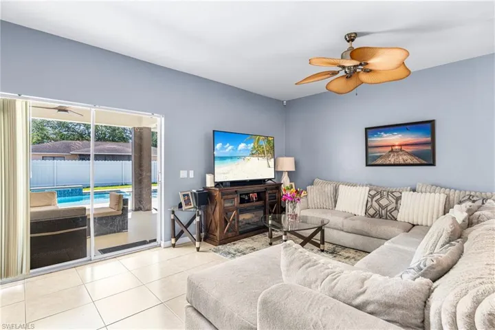 Expansive living area featuring light blue walls and neutral tile flooring