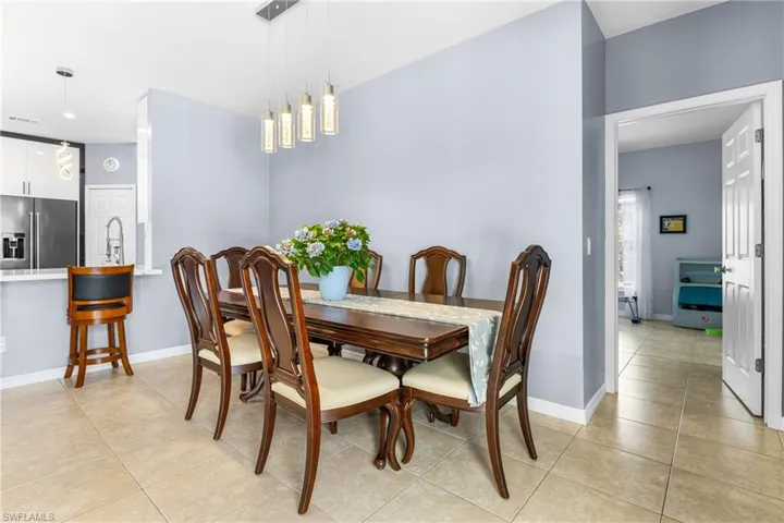 Dining area featuring a contemporary linear chandelier with five clear glass pendants