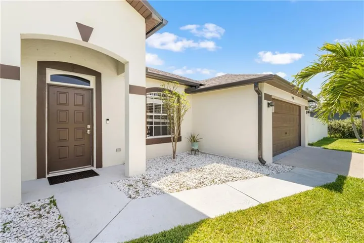 Inviting front exterior featuring a covered entry, an arched doorway, and a multi-panel door with an arched transom