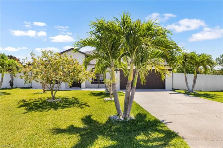 Contemporary residence featuring a white stucco exterior, dark brown garage doors, and a concrete driveway