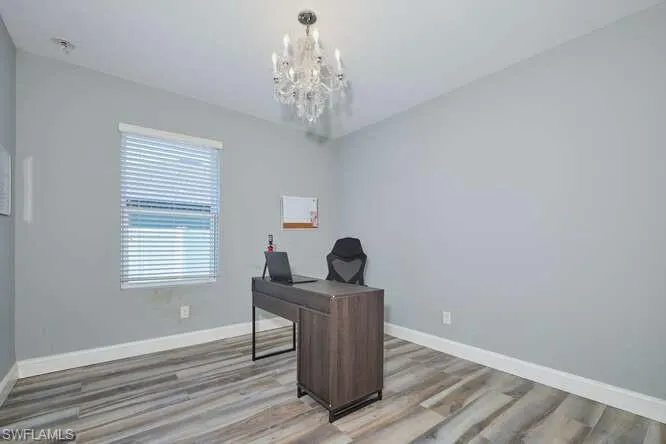 Office space featuring light wood finished floors and a chandelier