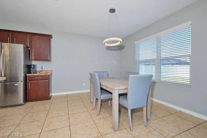Dining area with baseboards and light tile patterned flooring