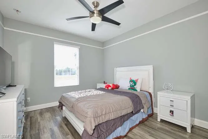 Bedroom featuring dark wood-style flooring and ceiling fan
