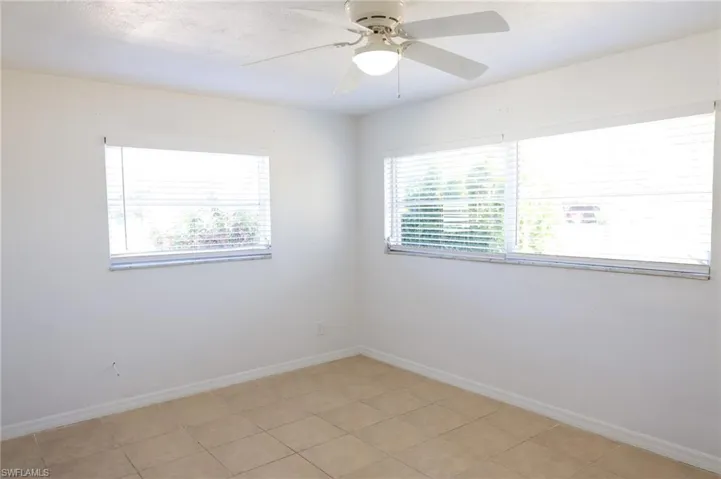 Spare room with a ceiling fan and light tile patterned floors