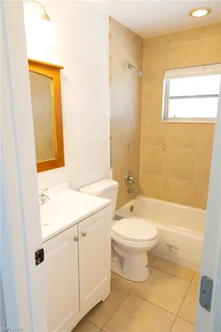 Bathroom with vanity, light tile patterned flooring, and bathtub / shower combination