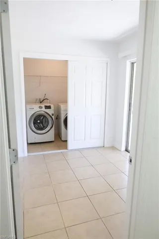 Washroom featuring light tile patterned flooring and separate washer and dryer