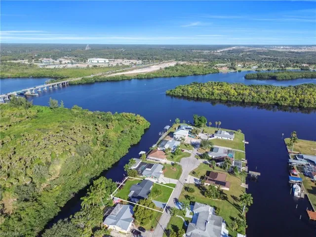 Aerial overview of property's location featuring a nearby body of water and nearby suburban area