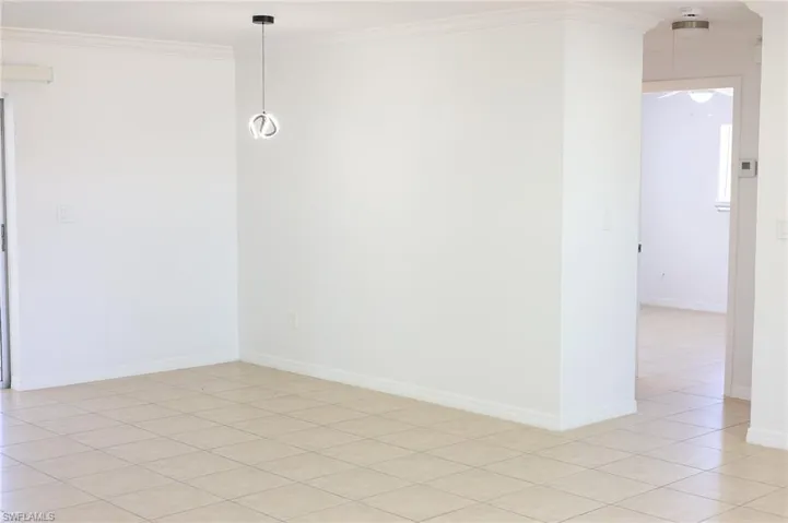 Spare room featuring ornamental molding and light tile patterned floors