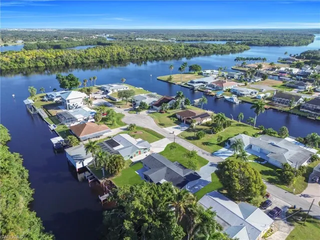 Aerial view of residential area with a nearby body of water and a forest