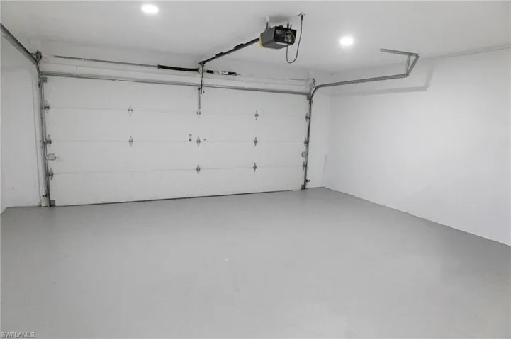 View of front of house with a front lawn, a garage, driveway, and stucco siding