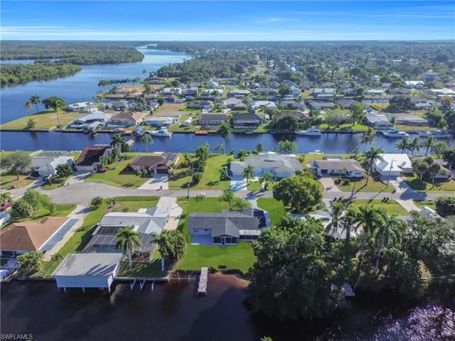 Aerial view of property's location with a large body of water and nearby suburban area