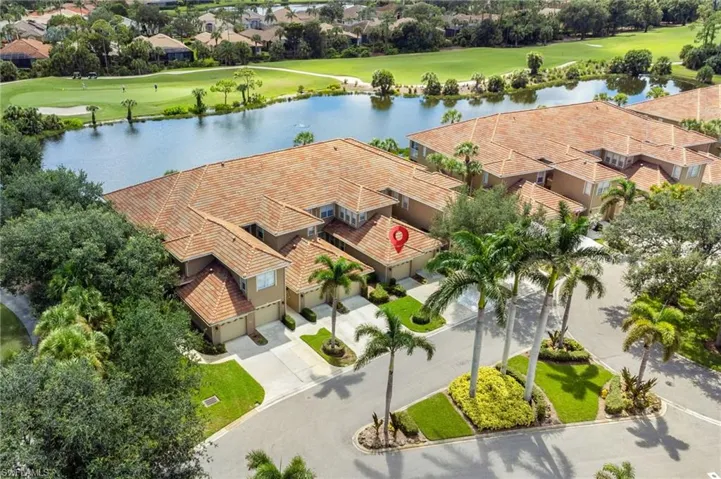 Aerial view of residential area featuring a local golf course and a large body of water