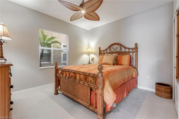 Bedroom with light carpet and a ceiling fan