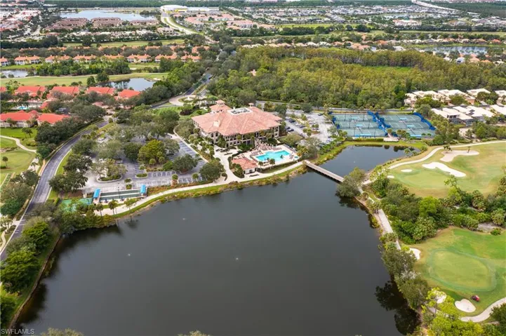 Aerial view of property and surrounding area featuring a local golf course and a nearby body of water