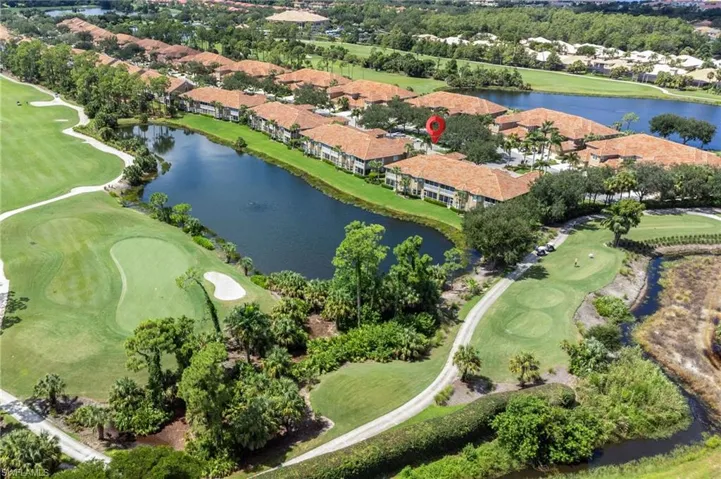 Aerial view of residential area featuring a local golf course and a large body of water