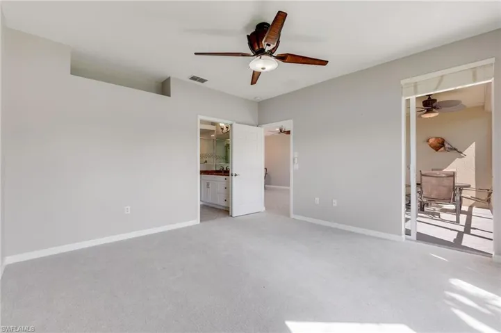 Unfurnished bedroom with light colored carpet, ensuite bath, a ceiling fan, and access to outside