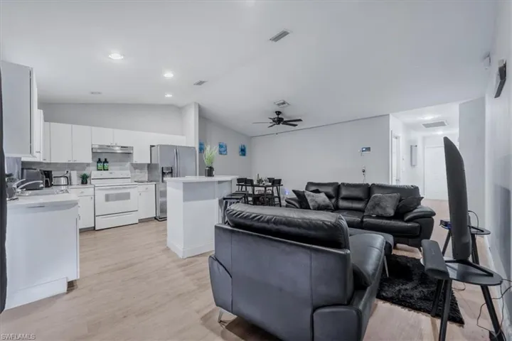 Spacious open-concept living area featuring wood-finish flooring, recessed lighting, and a ceiling fan