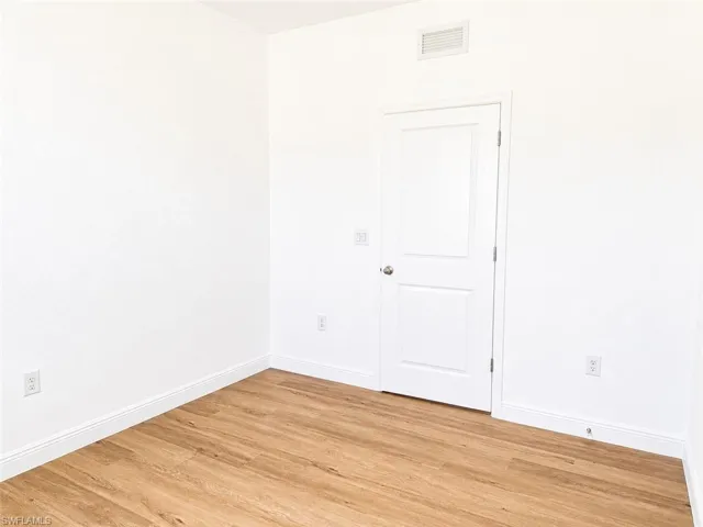 Light wood-finish flooring complements crisp white walls and baseboards