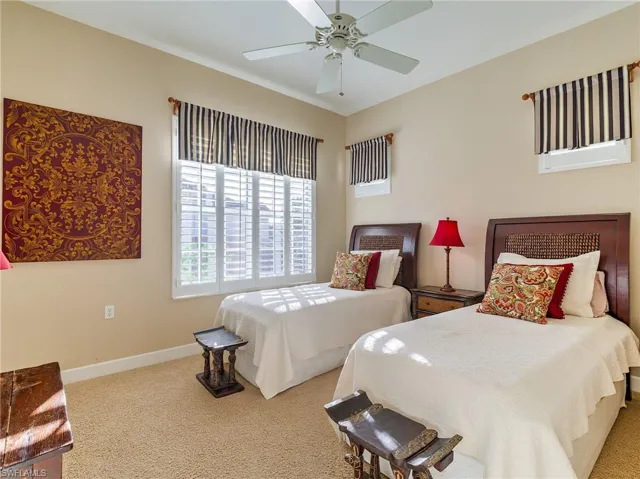 Carpeted bedroom featuring ceiling fan