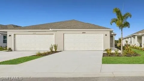View of front of property with a garage, concrete driveway, and stucco siding
