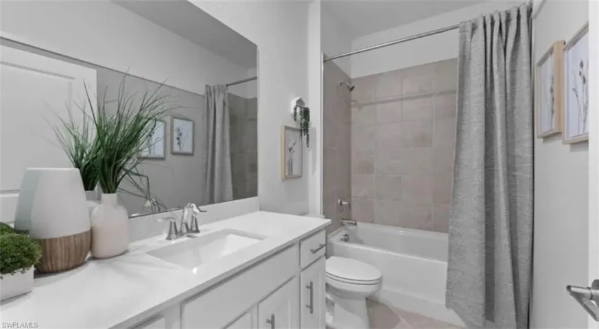Full bathroom with vanity, shower / tub combo, and light tile patterned floors
