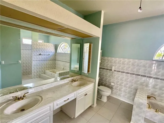 Full bath with plenty of natural light, tile patterned floors, and a sink