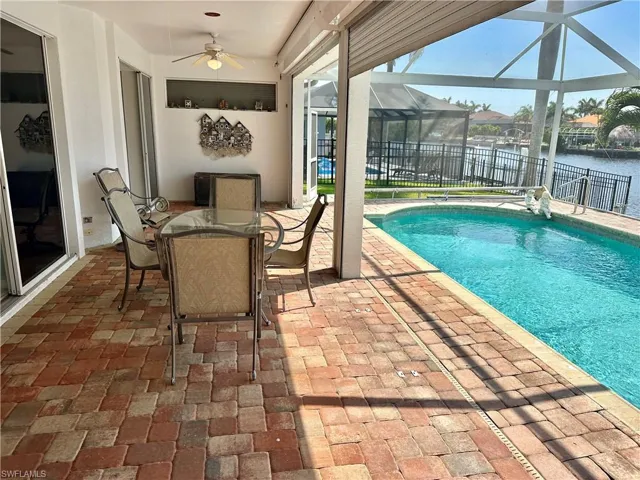 View of swimming pool featuring a fenced in pool, a lanai, fence, a ceiling fan, and a patio