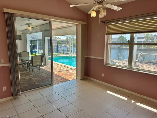 Dining space featuring plenty of natural light, a ceiling fan, baseboards, and light tile patterned flooring