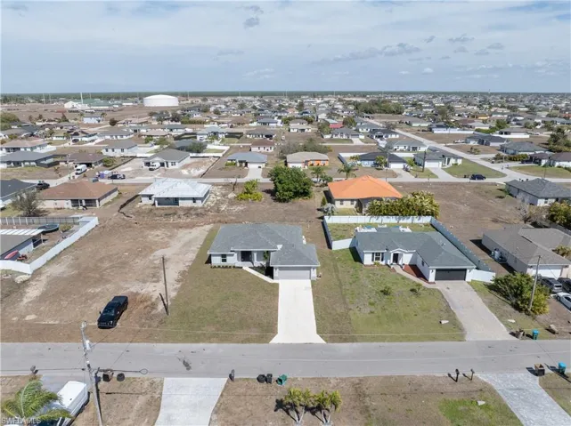 Aerial view of property and surrounding area featuring nearby suburban area