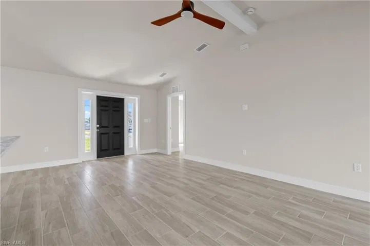 Foyer entrance with wood tiled floors, a ceiling fan, and lofted ceiling