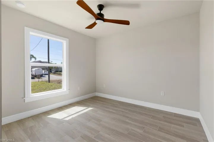 Unfurnished room with wood tiled floors and a ceiling fan