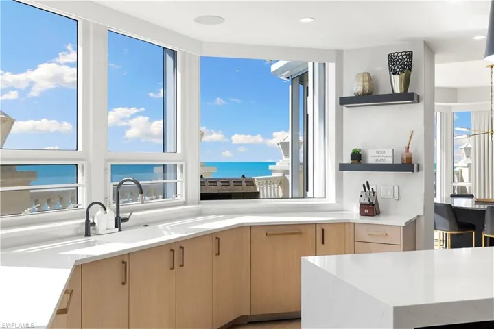 Kitchen with light wood finish cabinetry, light stone countertops, open shelves, modern cabinets, and recessed lighting